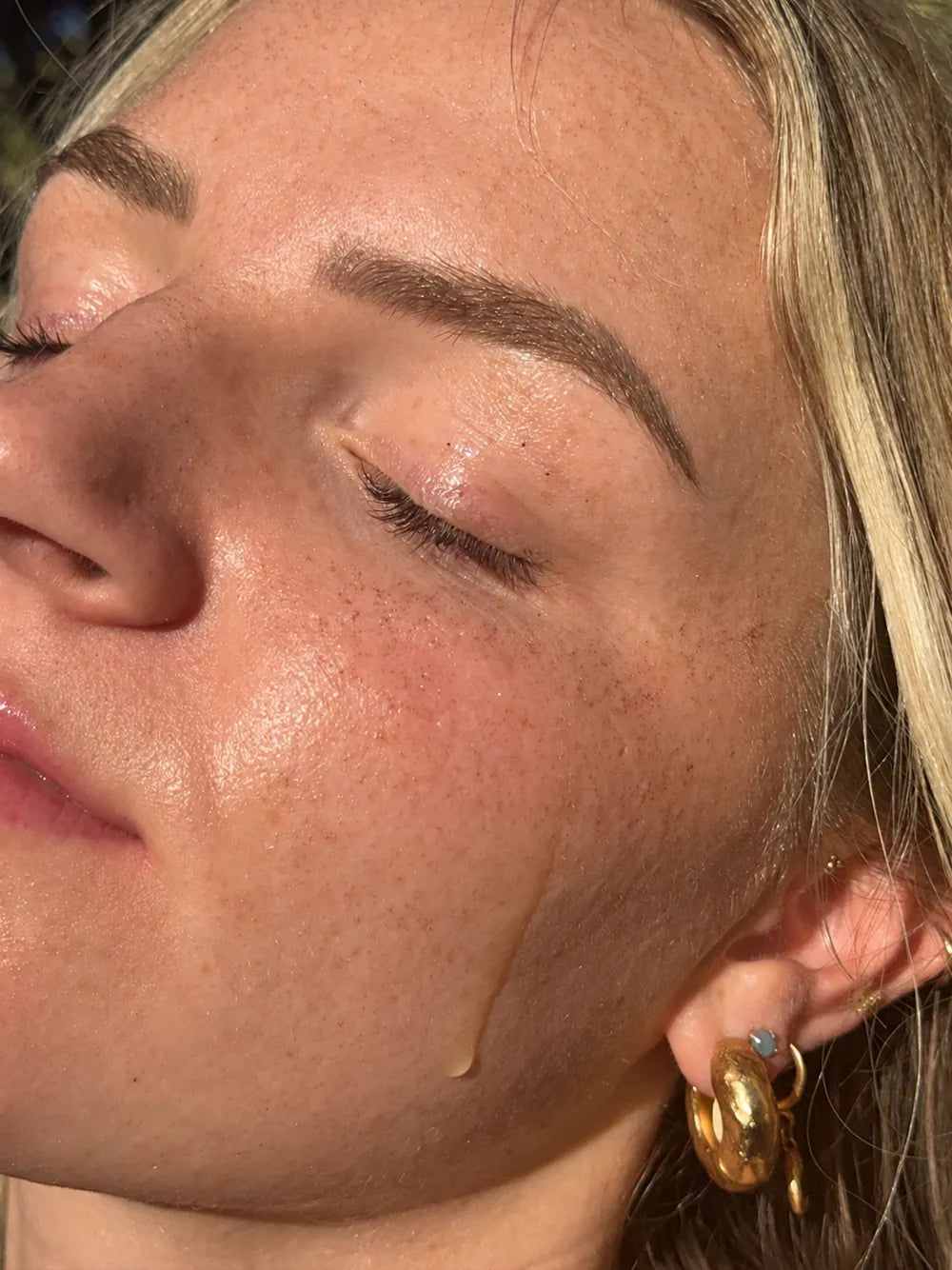 Close-up of serum on a cheek in natural light