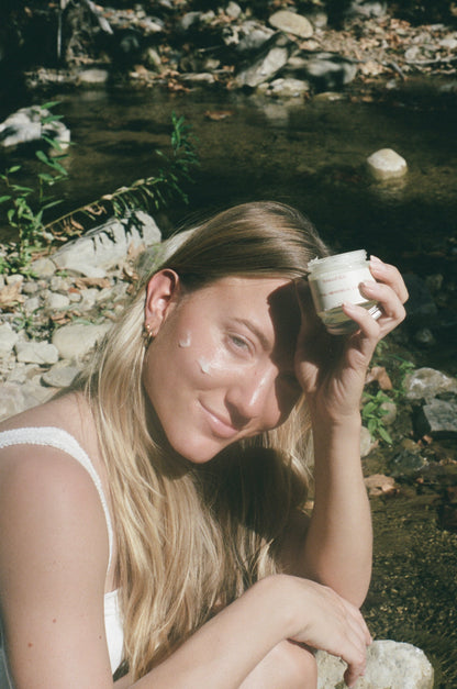 
Applying Luteal / Menstrual Balm outdoors by a creek