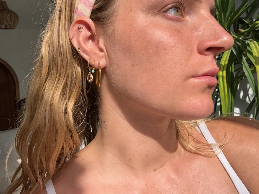 A close-up portrait of Madi wearing a floral headscarf.