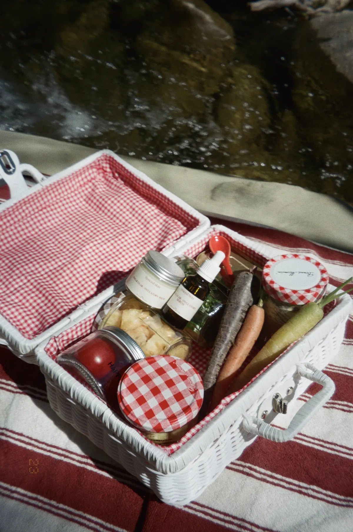 A picnic basket with Synced Skin products, fruit and vegetables.