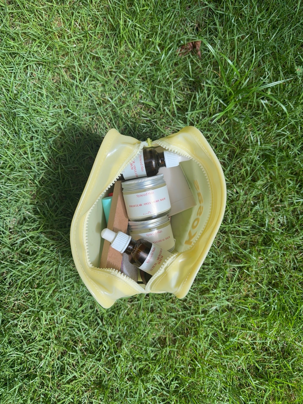 A Synced Skin kit in a yellow bag on grass.